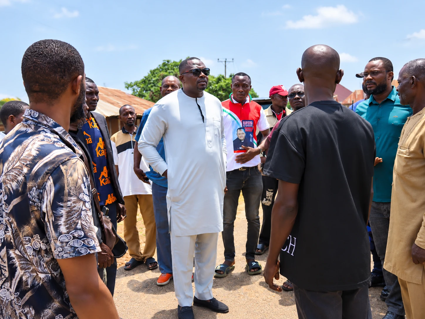 Community gathering around a village leader during Ojema's condolence visit